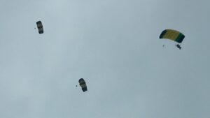 中共解放軍圍台軍演，國軍於潮州持續高空滲透跳傘訓練，展現堅定戰備決心與精湛操傘技巧，空訓中心教官及學員精準降落目標區，強化國軍專業訓練與防衛能力。