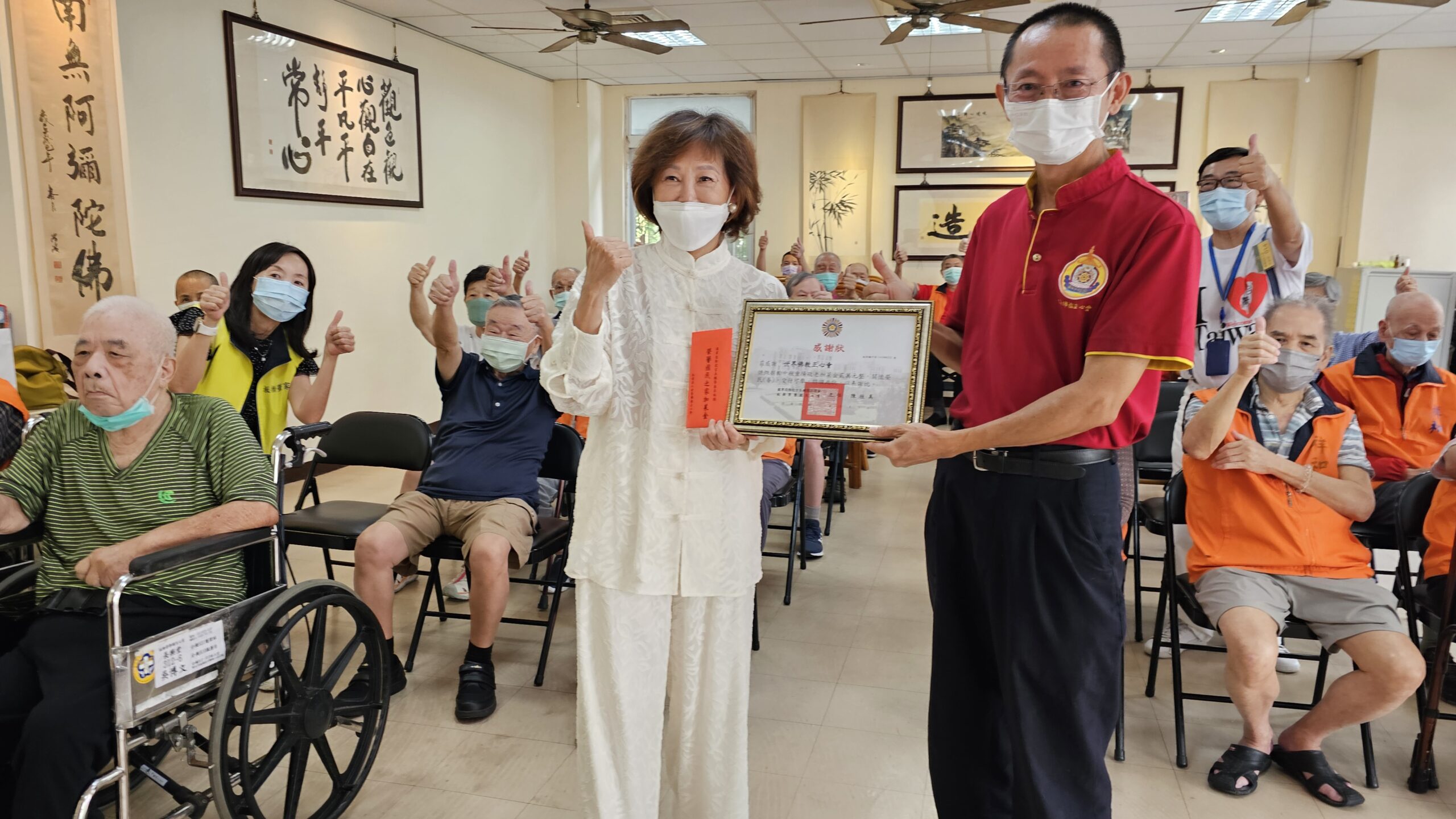 《圖說》世界佛教正心會致贈板橋榮家加菜金，家主任陳桂美代表領受。〈佛教正心會提供〉