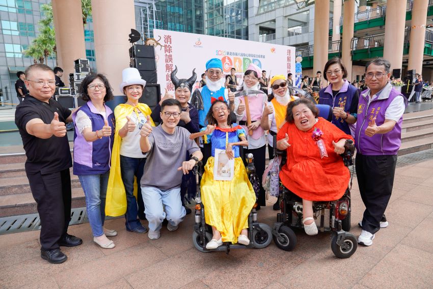 《圖說》新北市身心障礙綜合成果展今日登場，市府副秘書長張其強(灰衣者)及社會局長李美珍(右2)與表演者合影，左二副局長許秀能。〈社會局提供〉