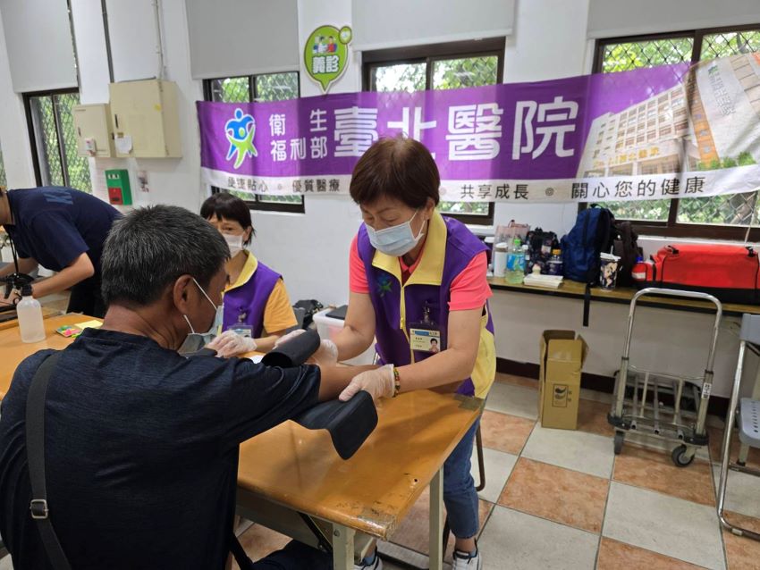 《圖說》臺北醫院志工為街友量血壓。〈臺北醫院提供〉