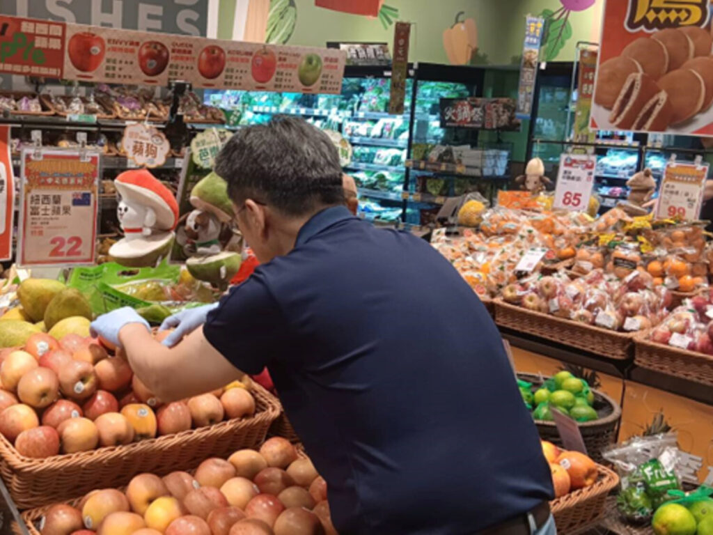 專注整理架上蔬果，讓顧客感受滿滿新鮮感。(圖/文山銀髮人才服務據點 提供)
