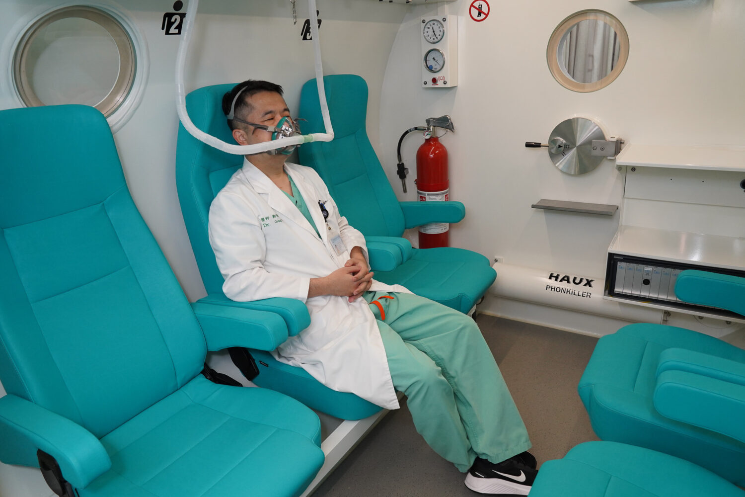 胸腔暨重症科鄭博斌醫師示範高壓氧艙內治療過程，患者於密閉艙內吸入100%純氧，能有效改善內耳缺氧、促進組織修復，加速突發性耳聾等疾病復原。（圖/記者張家燁翻攝）