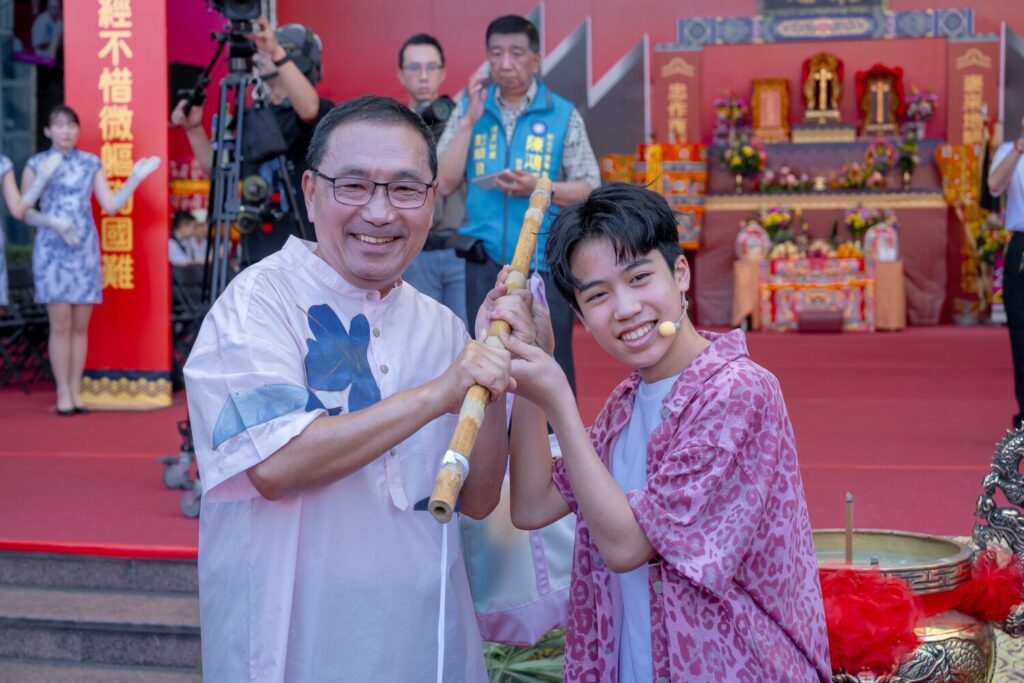 新北市市長侯友宜與JHall主唱子濬交接擔頭代表客家文化代代相傳、生生不息的精神。（圖/新北市客家事務局 提供）