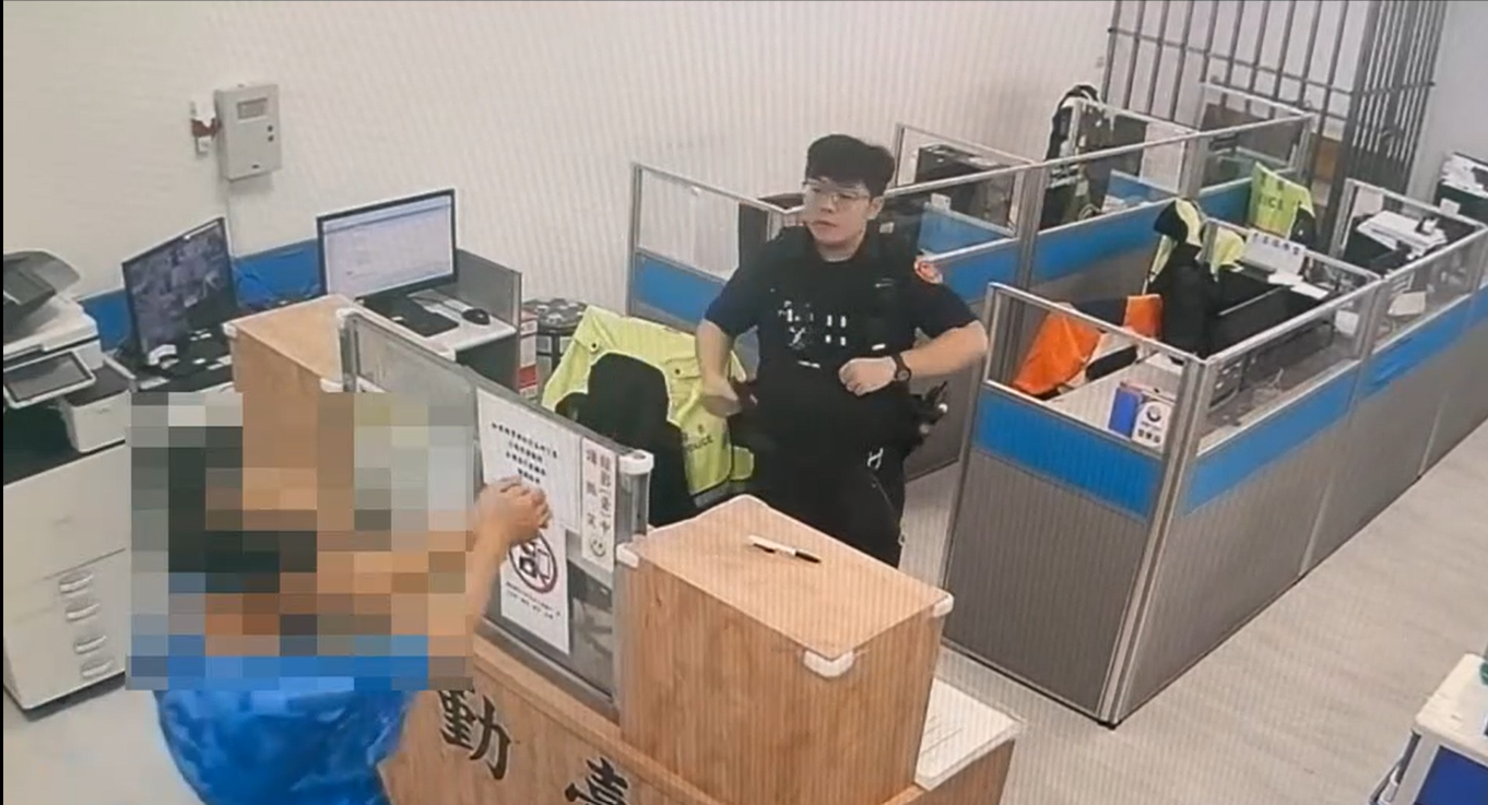 李男涉嫌殺害56歲妻子羅女，並於17日前往內壢派出所自首。到達警局後他主動將雙手靠攏、示意警員上銬。（記者翻攝）