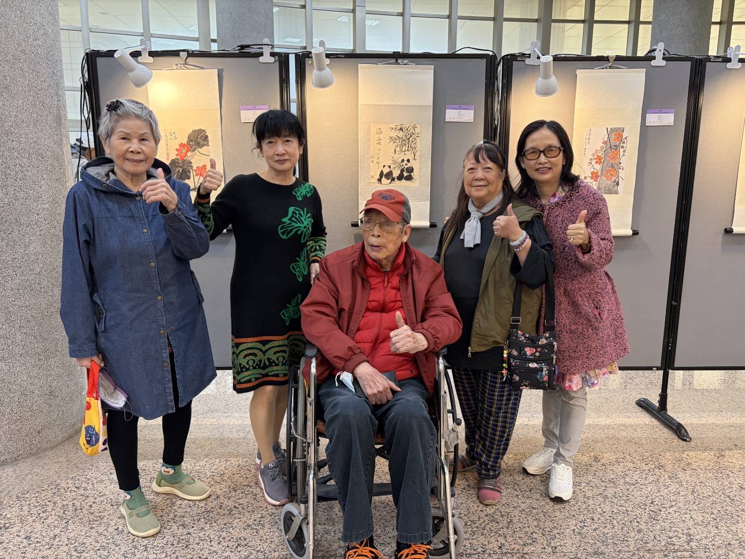 策展人林沛玲老師與長輩們在國畫作品前溫馨留念，分享學習成果的喜悅。（圖/記者黃溎芬翻攝）