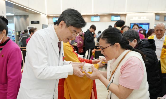 擇善寺臘八節寒冬送暖 臺北醫院飄粥香 32 《圖說》鄭舜平院長(左)致贈臘八粥給住院病友及就診民眾,祈願病友早日康復、大眾平安健康。〈臺北醫院提供〉