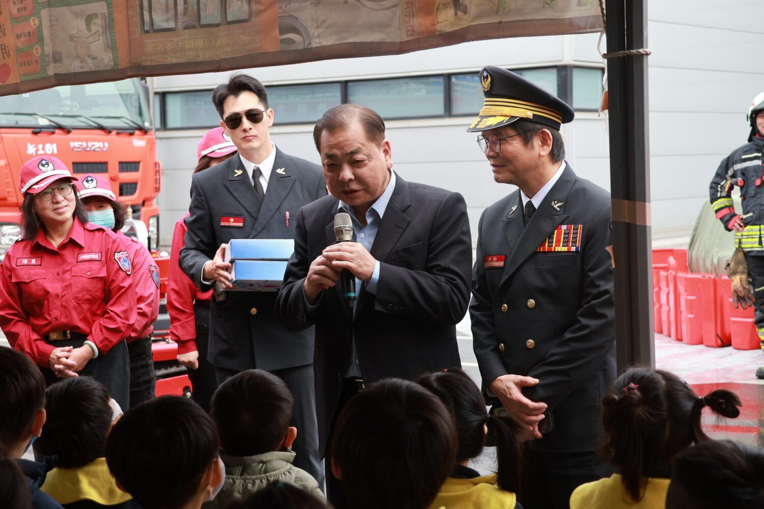 結合「科技救災與電動車火災」情境 新竹縣消防局強化工廠防災韌性 新竹縣政府消防局辦理大型工廠救災救護勤務演習,副縣長陳見賢於現場向參與活動之幼兒園學童進行防災安全宣導,透過近距離互動,向下扎根推廣防火、防災與逃生觀念。(圖/記者張家燁翻攝)