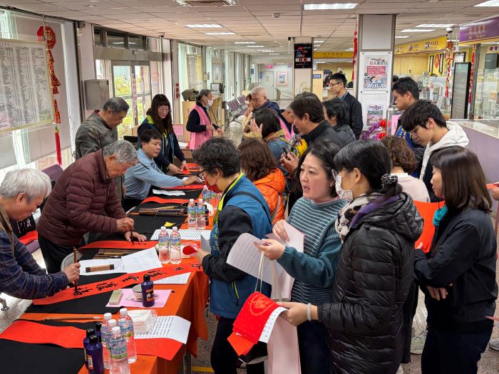 一馬當先開新進福 台電北西區處名師揮毫送春聯 36 《圖說》台電北西區處舉辦「名師揮毫送春聯 一馬當先開新進福」,民眾排隊領墨寶。〈台電北西區處提供〉