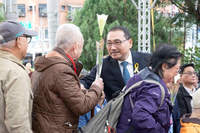 新北悼念二二八79周年 侯:盼團結台灣傳承和平信念 13 《圖說》侯友宜市長逐一遞送鐵炮百合給受難者家屬獻花,撫慰受難者心靈。〈民政局提供供〉