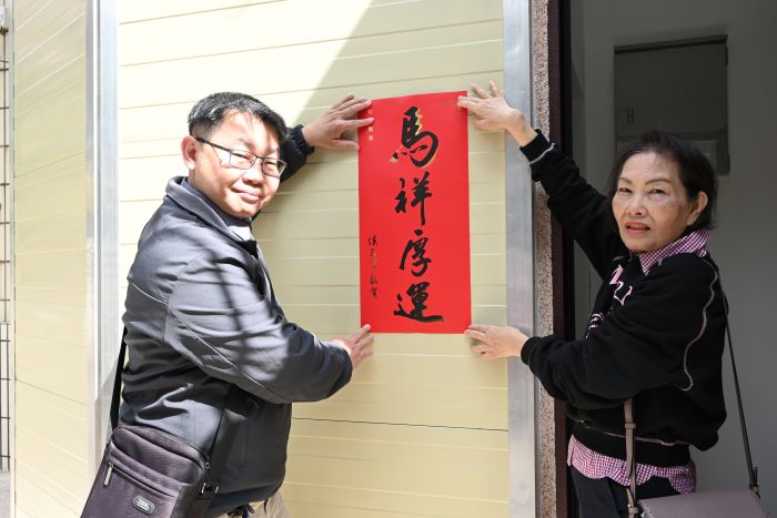 長輩輕鬆下樓 新北增設電梯補助加速老屋改善 40 《圖說》建築師與住戶一同將春聯張貼在電梯門口。〈城鄉局提供〉