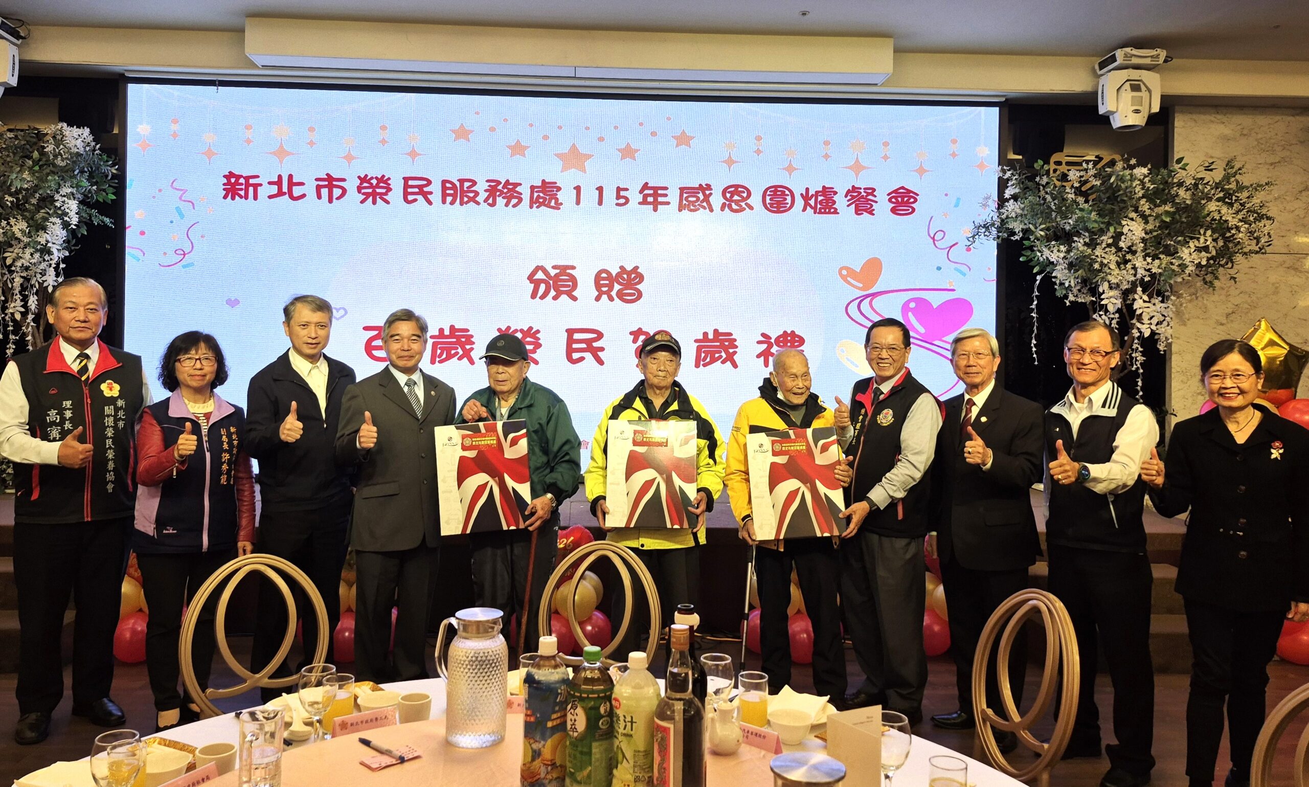 百歲人瑞高歌迎新 新北榮服處圍爐共享團圓飯香 26 《圖說》新北市榮民服務處處長林振生(左4)致贈賀禮予3位百歲榮民彭爺爺(左5)、羅爺爺(左6)及方爺爺(左7),並與出席貴賓合影留念。〈新北榮服處提供〉