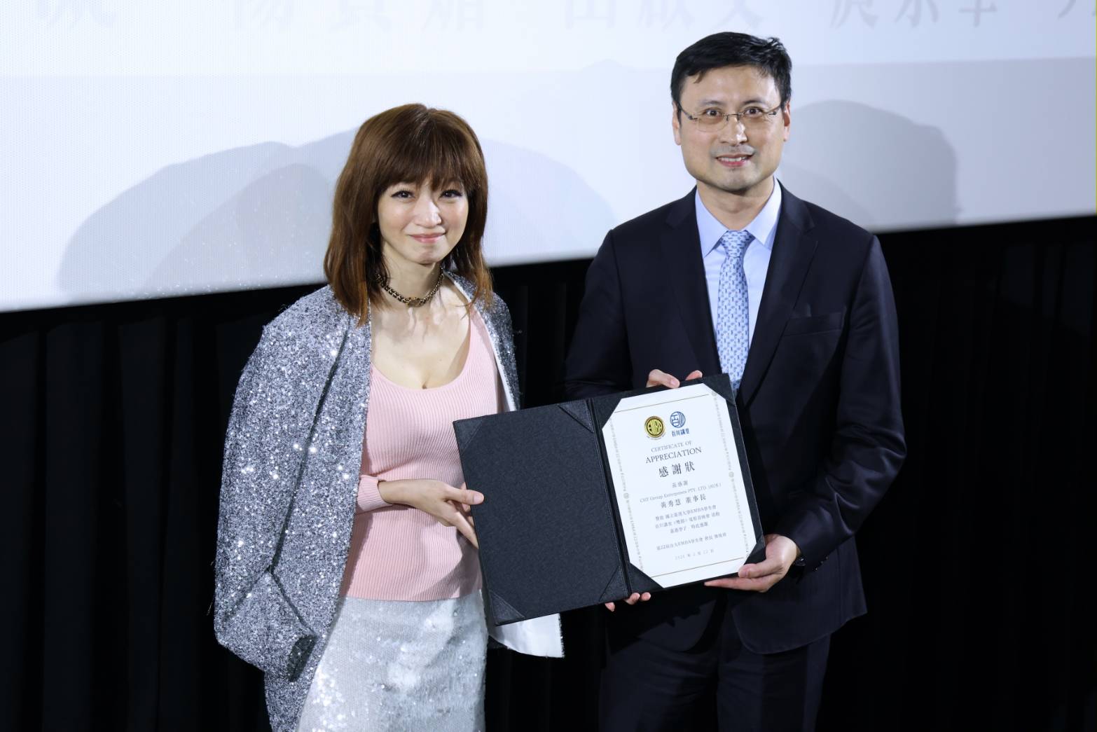 電影《雙囍》首映群星齊聚 臺大EMBA校友基金會副執行長黃秀慧包場支持電影 為感謝黃秀慧對本次活動的鼎力支持,臺大EMBA第22屆學生會長熊俊瑋特別代表百川講堂頒發感謝狀。(圖/主辦 提供)