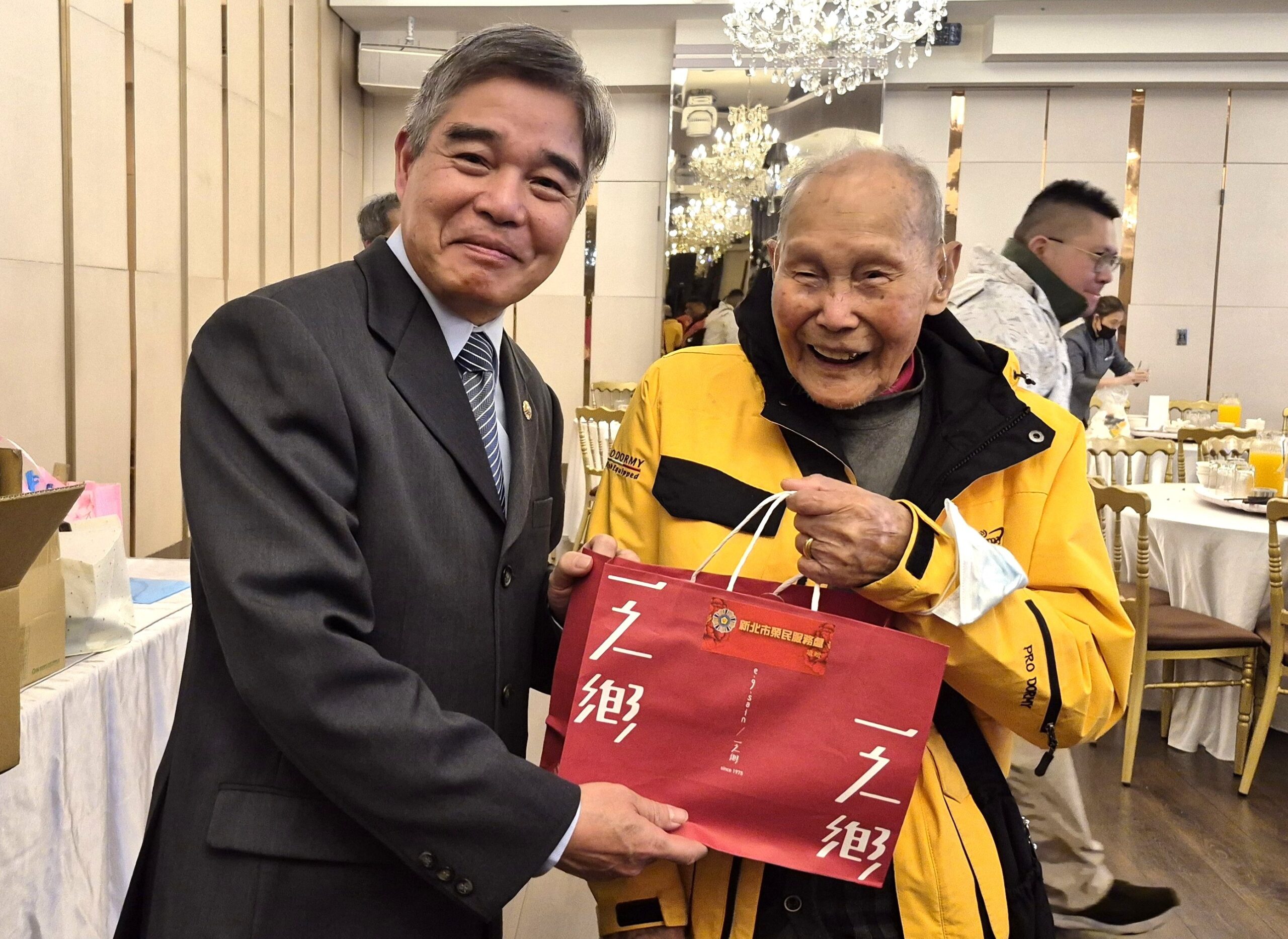 百歲人瑞高歌迎新 新北榮服處圍爐共享團圓飯香 28 《圖說》林振生處長(左)致贈伴手禮予106歲方爺爺。〈新北榮服處提供〉