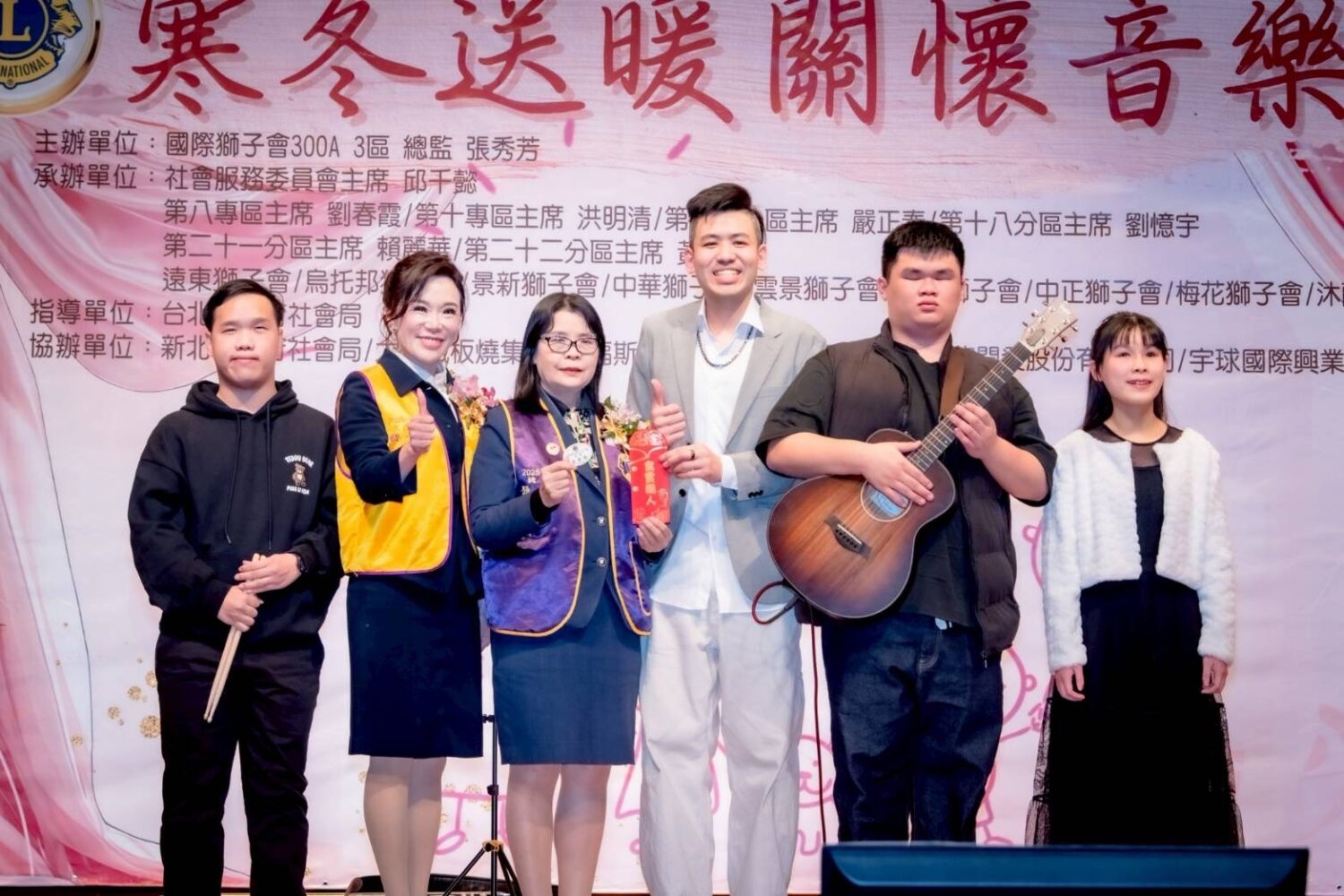寒冬送暖365份紅包 主席邱千懿率獅子會助弱勢兒少 由大直獅子會謝承融主席組成「放聲座標」視障樂團首登大舞台。(圖/記者 張泓笙翻攝)