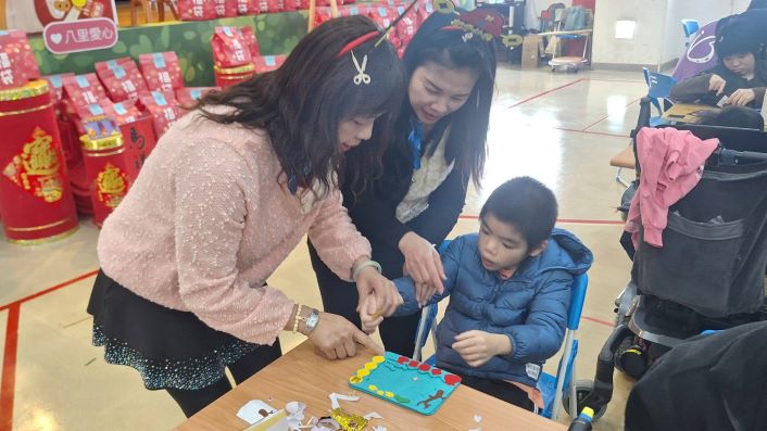 八里院生有依靠 志工「幸福加馬」15年暖心同行 28 《圖說》院生阿忠(右)和志工惠真(左1)與秋香(中)一起創作相框DIY。〈社會局提供〉