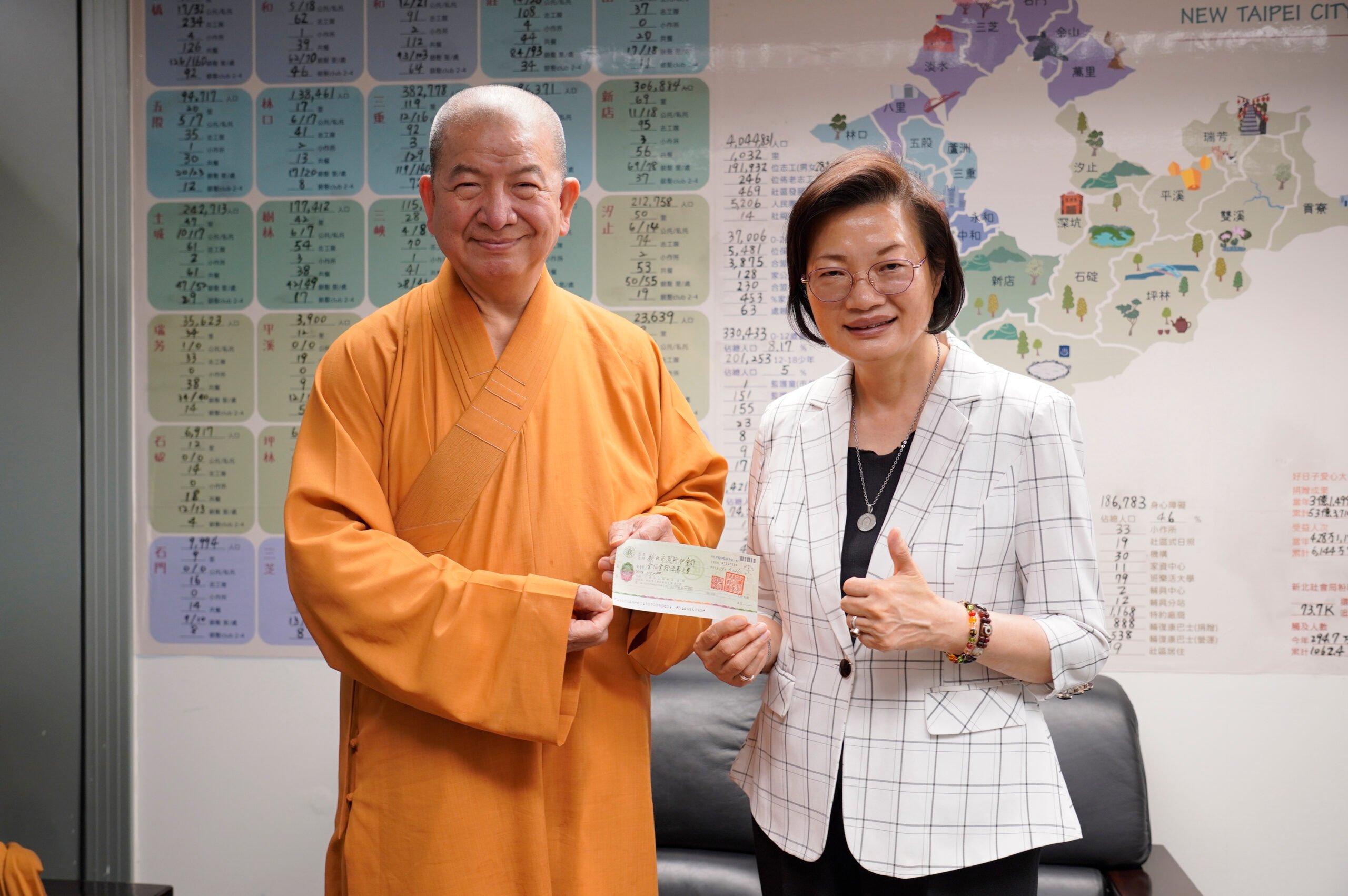 萬罐奶粉+千萬捐助 兩善團關懷弱幼長年守護新北 10 《圖說》新北市佛教會副理事長釋明光(左)代表捐贈善款,由社會局長李美珍代表受贈。〈社會局提供〉