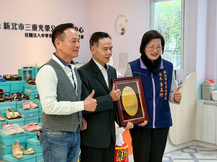 李余典媒合 美萬新捐贈童鞋 47 《圖說》社會局長李美珍代表侯友宜市長回贈感謝牌給美萬新企業總經理王秋鴻(中),左為居間媒合的李余典議員。〈社會局提供〉