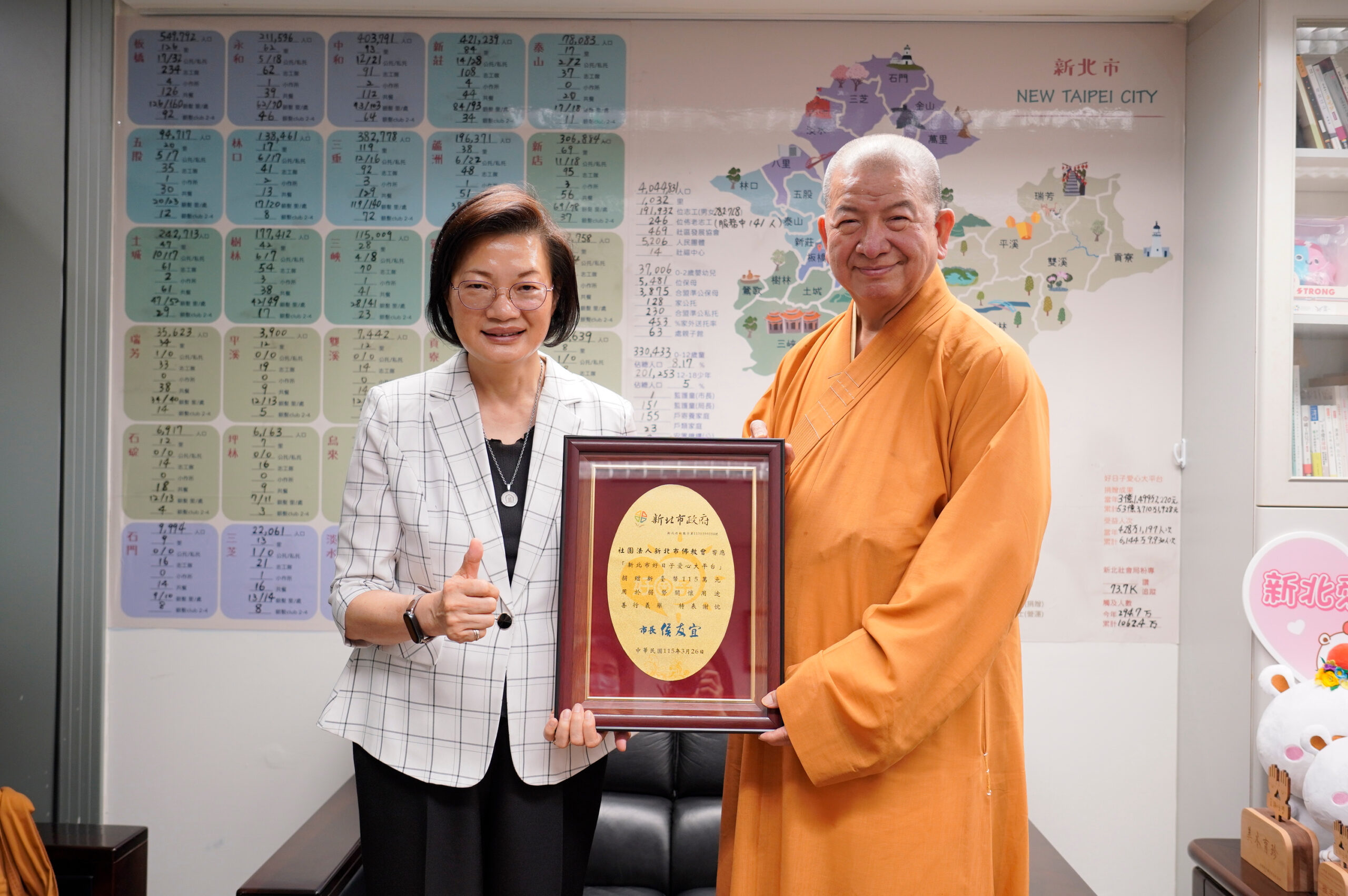 萬罐奶粉+千萬捐助 兩善團關懷弱幼長年守護新北 11 《圖說》社會局長李美珍代表代表侯友宜市長回贈感謝牌給釋明光法師。〈社會局提供〉