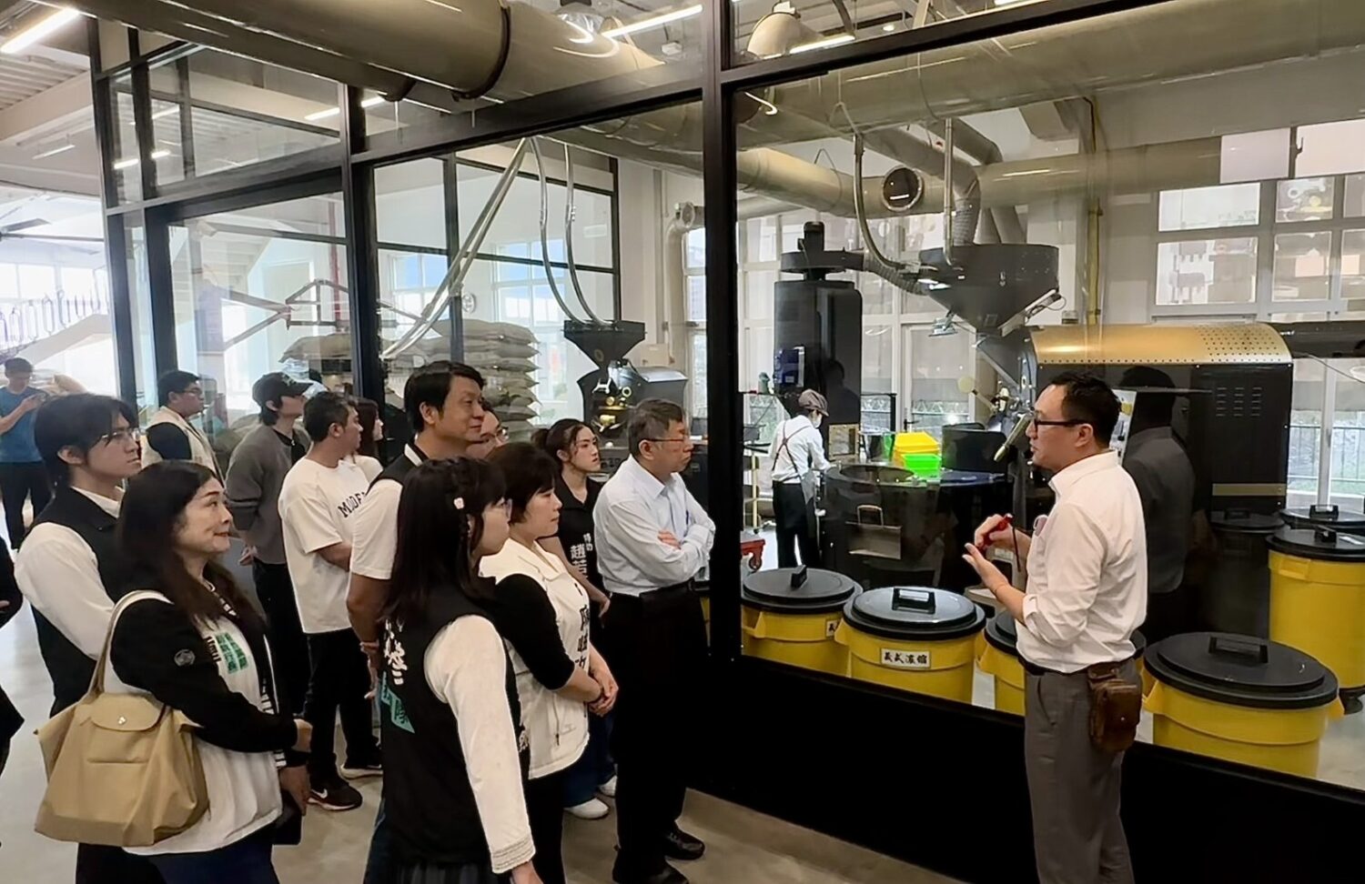 「柯文哲參訪赫曼咖啡」電費砍半、瓦斯省4成 綠電工廠成轉型範本 赫曼咖啡王進忠總經理導覽工廠烘焙設備與製程流程,說明導入光儲整合系統後的節能成果。(圖/記者林照東翻攝)