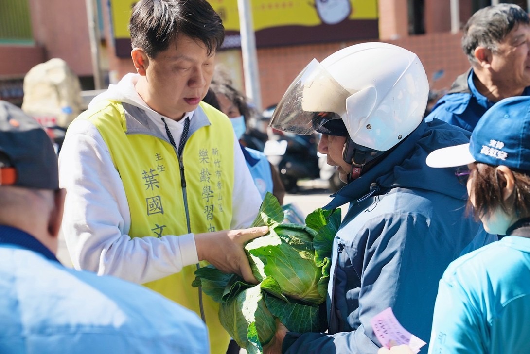 「10元換高麗菜送暖香山」500顆半小時發放完畢助青農也助弱勢 香山區樂齡學習中心主任葉國文於活動現場親自發放高麗菜給民眾,以實際行動支持青農、關懷弱勢。(圖/記者林照東翻攝)