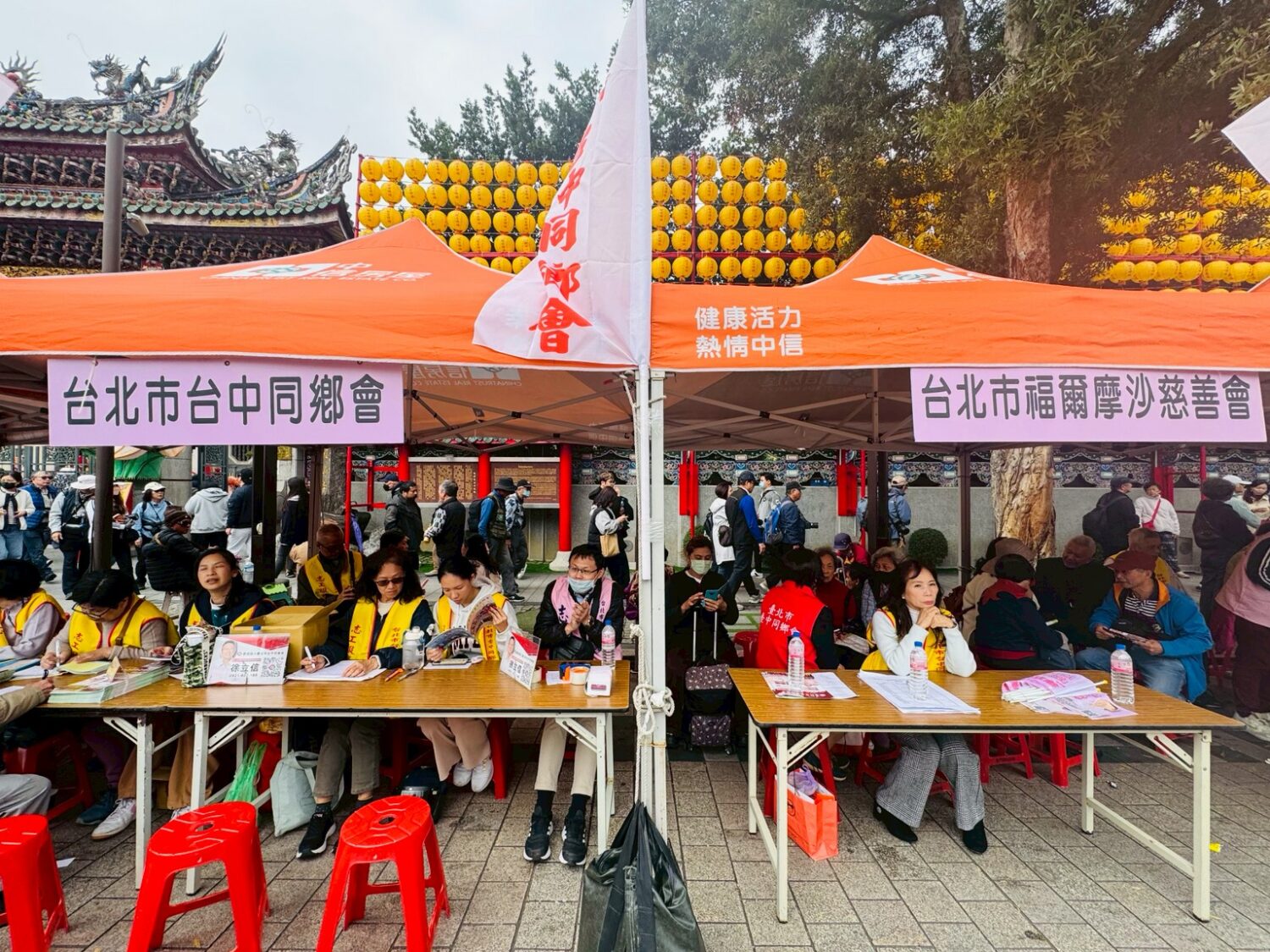 徐立信議員發放「愛心艾馨消費券」 里長齊聚相挺振興在地經濟 主辦單位臺北市臺中同鄉會及福爾摩沙慈善會於萬華龍山寺前廣場設置服務攤位,協助民眾領取消費券並提供入會諮詢。(圖/記者 陳蒂蒂攝)