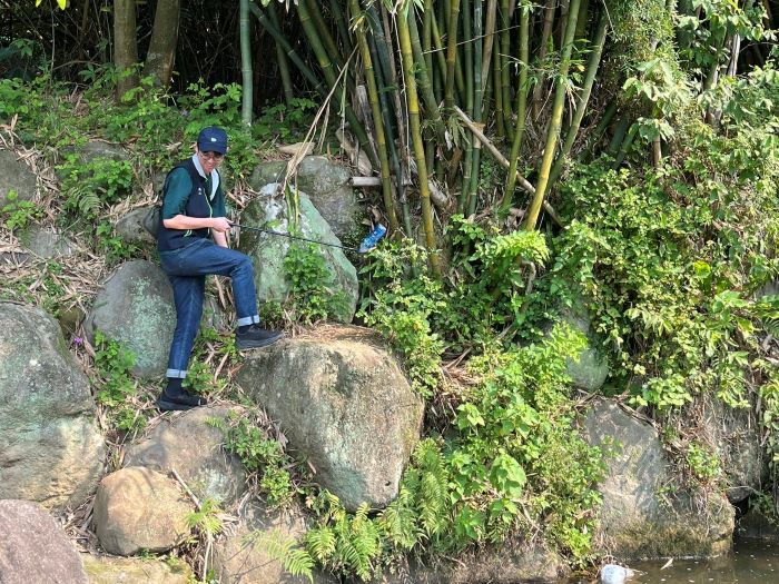 倡議自然共好 台電北市區處攜手家屬守護山林 40 《圖說》台電同仁不畏艱難深入石縫撿拾廢棄物 還給山林純粹原貌。〈台電台北市區處提供〉