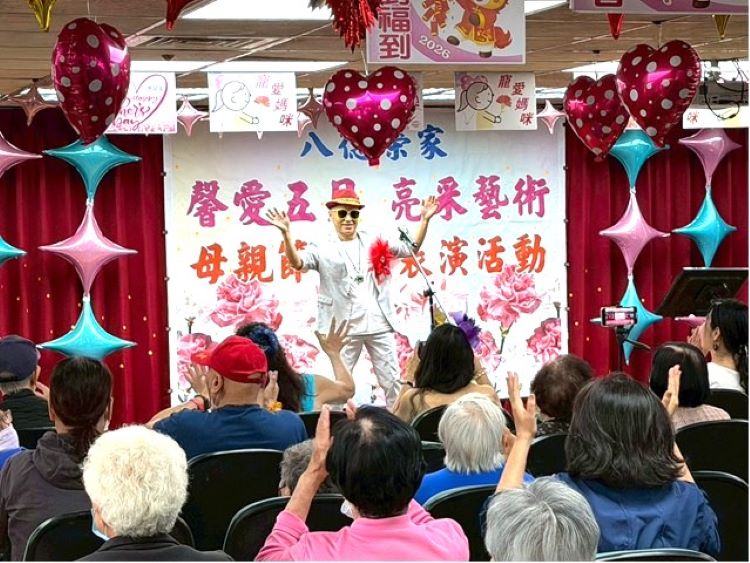 母親節前夕慰問八德榮家 亮采藝術團隊馨愛五月送暖 40 《圖說》亮采藝術關懷團隊表演者於舞台上帶動氣氛(前方),透過熱情演出與互動引領住民長輩一同揮手響應,現場掌聲與笑聲不斷,洋溢歡樂與感動。〈八德榮家提供〉