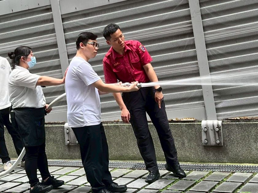 迎戰端午連假人流 新北消聯手百貨業守護民眾安全 18 《圖說》參訓人員親身體驗滅火器噴射時的後座力。〈第一大隊提供〉