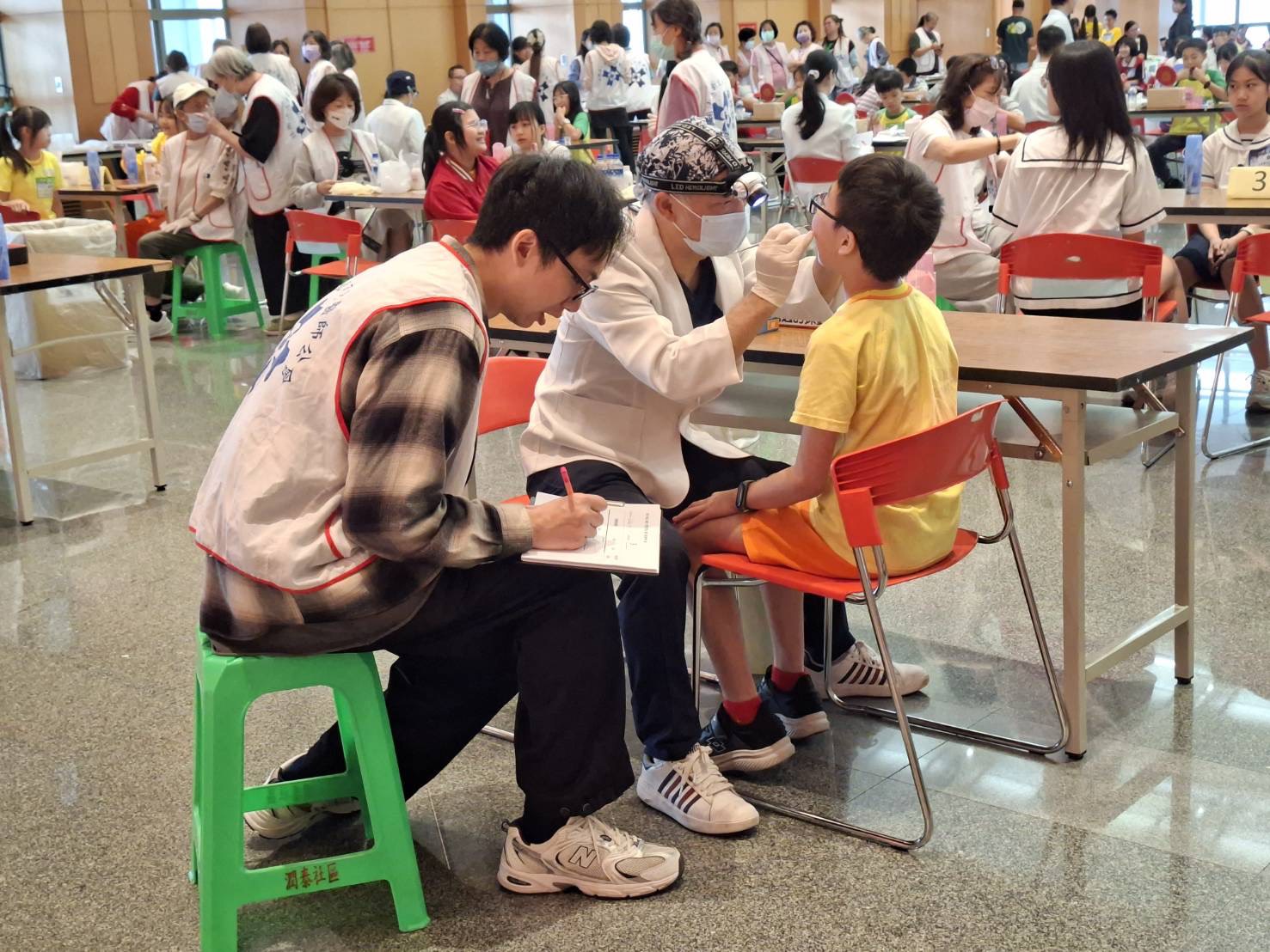新北潔牙賽登場 22校拚護齒 育德、中湖出線進軍全國 56 《圖說》「2026年新北市國小學童潔牙比賽—刷牙小英雄 拒檳護齒大作戰」,牙醫師詳細檢查參賽學童潔牙情形。〈衛生局提供〉