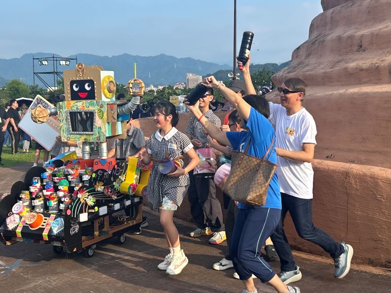 新北創客祭攜手夏至音樂節登場 26輛創意花車踩街嗨翻新美館 13 《圖說》北新國小施裕明校長和師生們與他們製作的「創客E學園」創意花車開心舞蹈。〈教育局提供〉