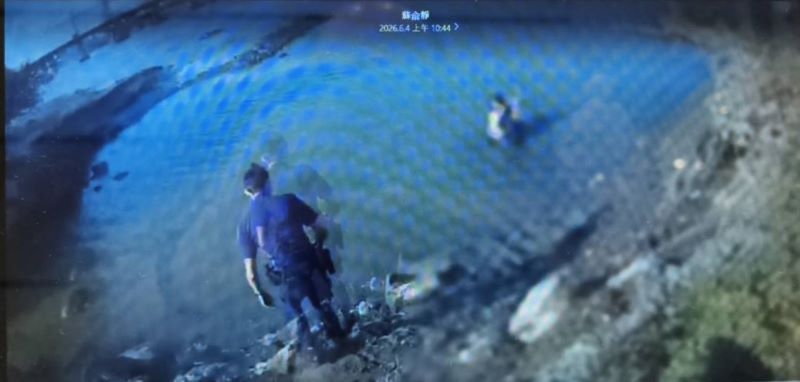 婦人失足落水載浮載沉 海山警奮勇下水泥濘中救回 6 《圖說》海山警當機立斷涉水下河救援。〈海山分局提供〉