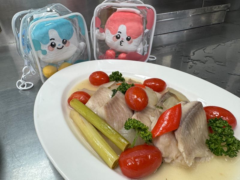 世界美食進校園 新北校廚研發異國料理豐富午餐 22 《圖說》「拿坡里水煮魚」融合義式拿坡里風味與健康烹調理念,以番茄、香草及多樣蔬菜襯托魚肉鮮甜,呈現兼具營養、美味與國際特色的創新校園料理。〈教育局提供〉