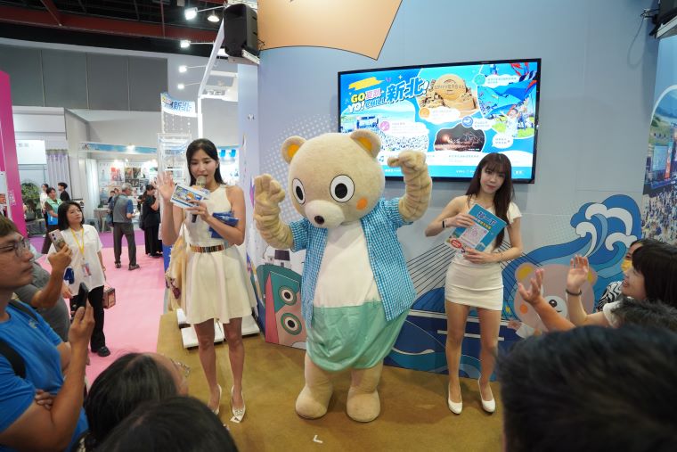 台北國際夏季旅展開跑 新北館抽獎加碼搶攻暑期商機 8 《圖說》新北市觀光吉祥物「小客」歡樂現身,與主持人共同帶動現場熱烈氣氛,吸引民眾熱情參與互動。〈觀旅局提供〉