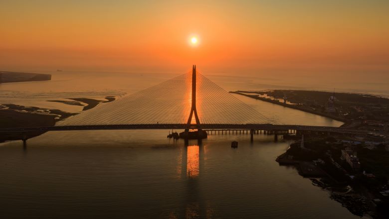 台北夏季旅展7/17登場 新北館6業者推優惠手作DIY吸客 25 《圖說》淡水河口的金黃夕照與宏偉的淡江大橋巧妙相遇,橋塔的俐落剪影與波光 粼粼的水面勾勒出專屬淡八地區的嶄新觀光地標。〈觀旅局提供〉