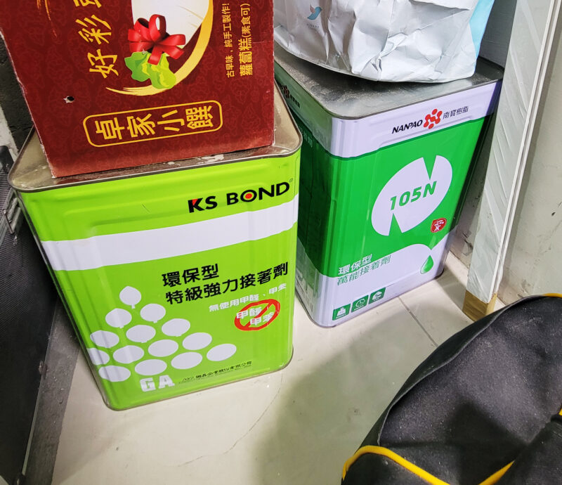 室內設計公司的工程管理在做什麼?施工期間可以確認的5件事 施工現場並排的兩罐接著劑,罐標為KS BOND環保型特級強力接著劑,標示無使用甲醛、甲苯,以及南寶105N環保型萬能接著劑